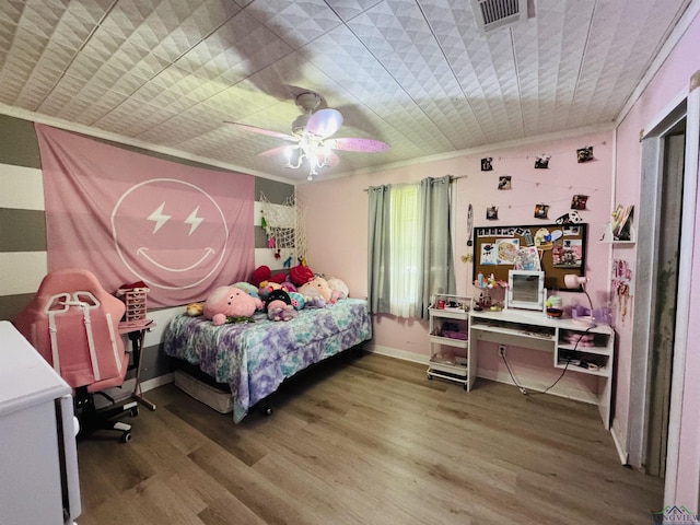 bedroom featuring ceiling fan, wood-type flooring, and ornamental molding