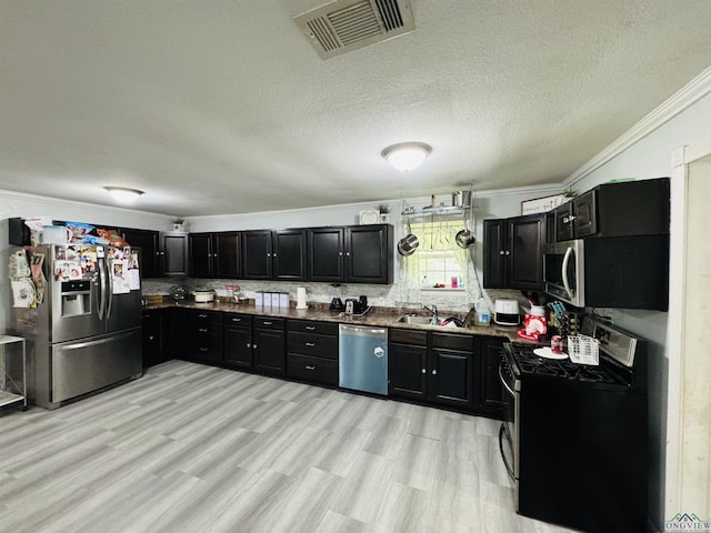 kitchen with appliances with stainless steel finishes, tasteful backsplash, ornamental molding, a textured ceiling, and sink