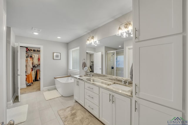 17182 Ironwood Dr, Flint, TX 75762 - bathroom with a stall shower, a spacious closet, double vanity, a soaking tub, and tile patterned flooring