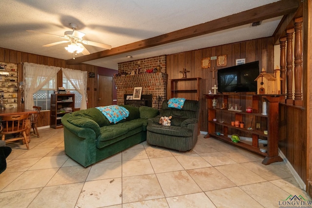 living room featuring beam ceiling, wood walls, and a ceiling fan