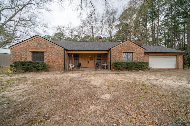 single story home featuring brick siding, roof with shingles, a chimney, a garage, and driveway