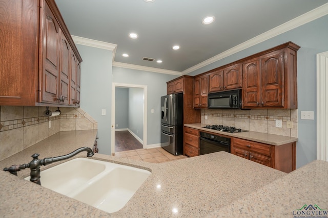 kitchen with backsplash, black appliances, sink, ornamental molding, and light tile patterned floors