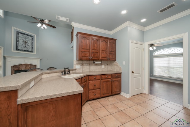 kitchen with light tile patterned flooring, kitchen peninsula, and sink