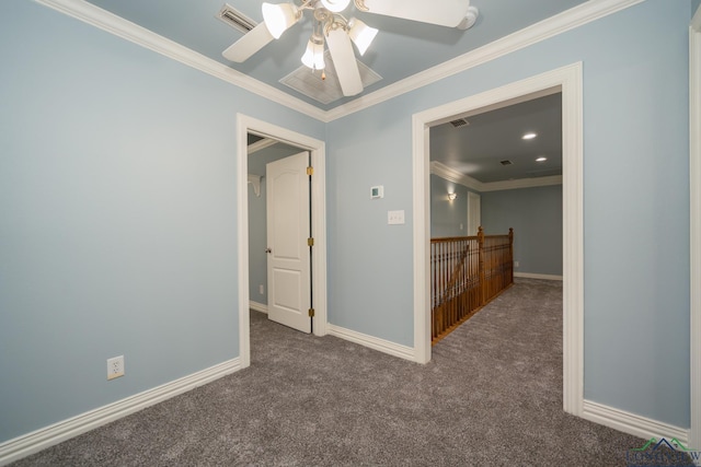 spare room featuring crown molding, ceiling fan, and dark colored carpet