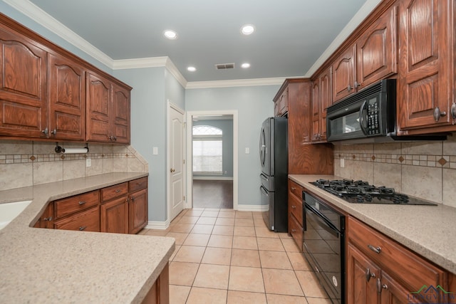 kitchen featuring decorative backsplash, light tile patterned floors, crown molding, and black appliances