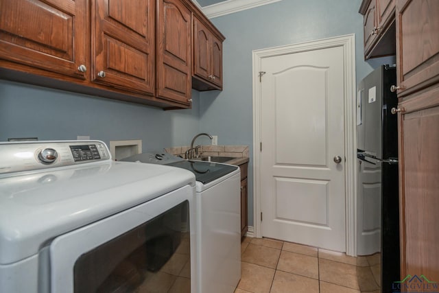 laundry room with sink, cabinets, separate washer and dryer, light tile patterned flooring, and ornamental molding