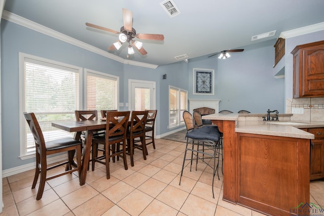 dining room featuring ceiling fan, sink, and light tile patterned floors