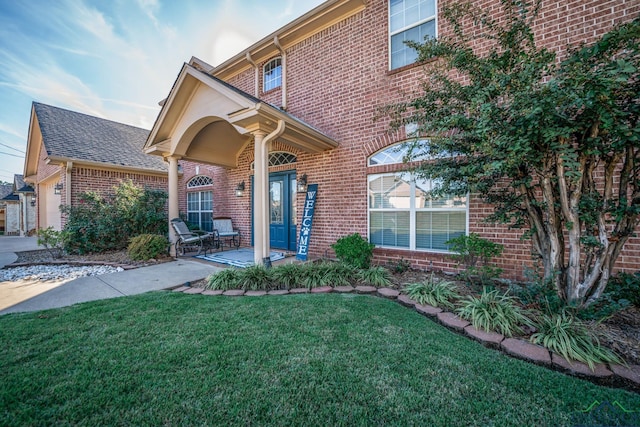 entrance to property featuring covered porch and a lawn