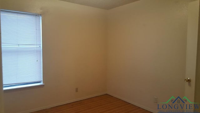 spare room featuring a textured ceiling and wood-type flooring