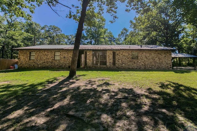 rear view of house featuring a yard