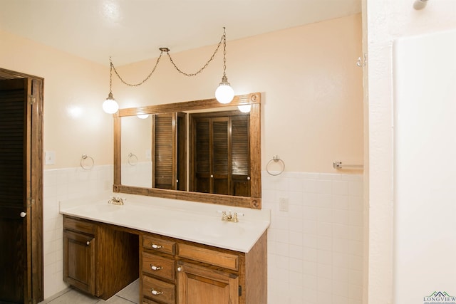 bathroom with tile patterned flooring, vanity, and tile walls