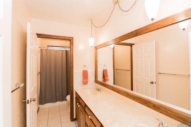 bathroom with toilet, vanity, and tile patterned floors