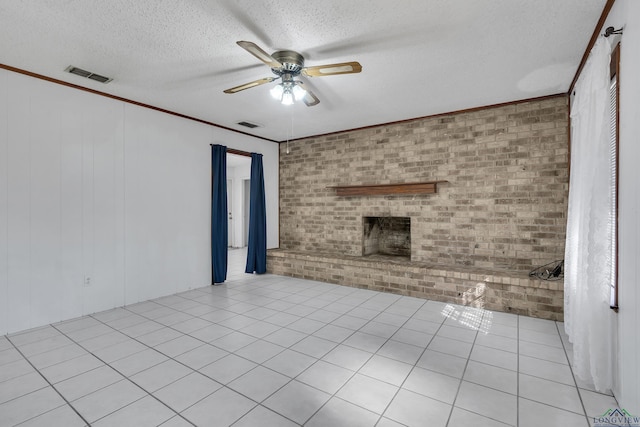 unfurnished living room with a brick fireplace, a textured ceiling, ceiling fan, brick wall, and ornamental molding