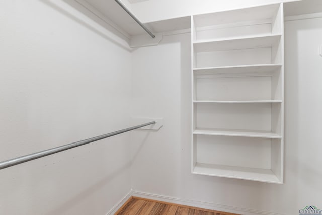 walk in closet with light hardwood / wood-style flooring