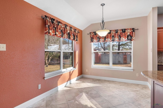 unfurnished dining area with light tile patterned flooring, plenty of natural light, and lofted ceiling