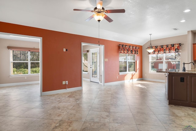 interior space featuring lofted ceiling, light tile patterned floors, sink, and ceiling fan