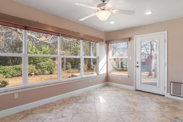 unfurnished sunroom featuring ceiling fan