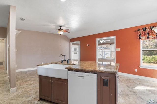 kitchen featuring sink, ceiling fan, a kitchen island with sink, white dishwasher, and light stone counters