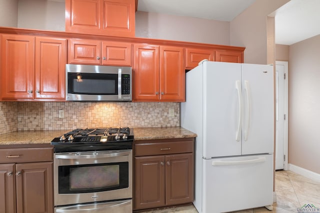 kitchen featuring light stone countertops, appliances with stainless steel finishes, and decorative backsplash