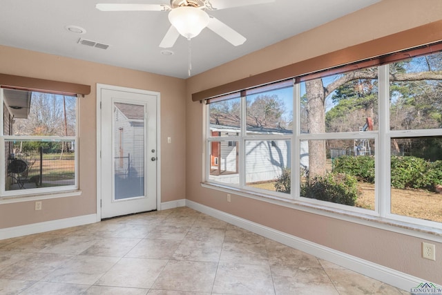 unfurnished sunroom with ceiling fan