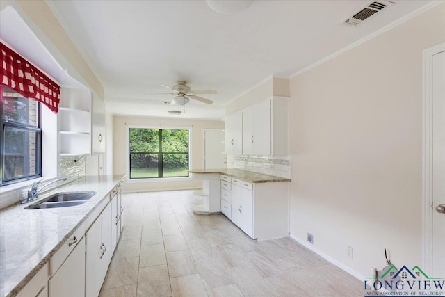 104 Mackinnon St, Mount Pleasant, TX 75455 - kitchen with a sink, open shelves, a ceiling fan, white cabinets, and backsplash