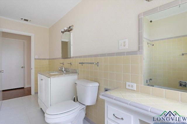 104 Mackinnon St, Mount Pleasant, TX 75455 - bathroom with vanity, toilet, tile walls, shower / bathtub combination, and tile patterned flooring