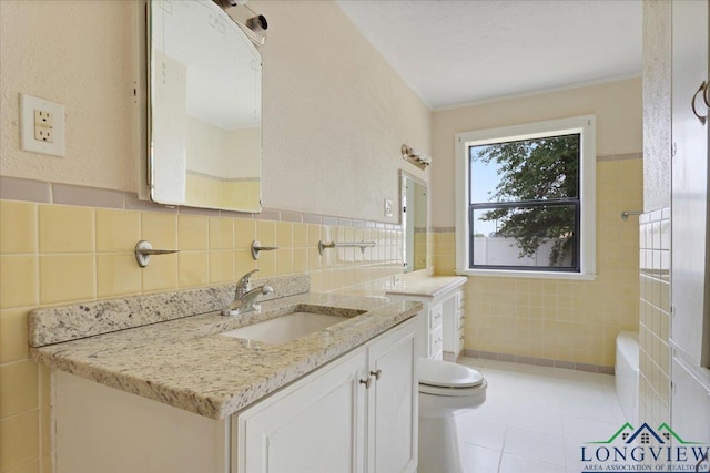 104 Mackinnon St, Mount Pleasant, TX 75455 - bathroom with tile walls, vanity, toilet, and tile patterned flooring