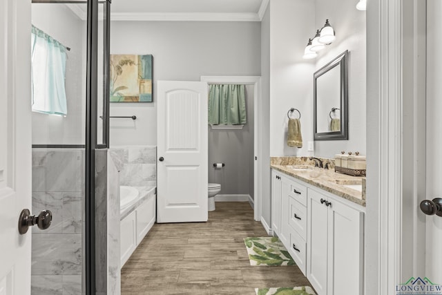 bathroom with a bath, hardwood / wood-style floors, toilet, vanity, and ornamental molding