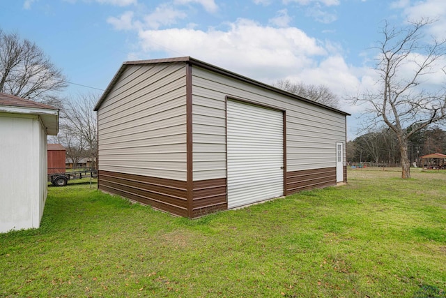 view of outdoor structure featuring a garage and a lawn