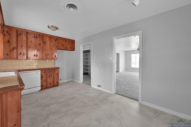 202 W Rocky Creek Rd, Houston, TX 77076 - kitchen with white dishwasher, brown cabinets, and baseboards