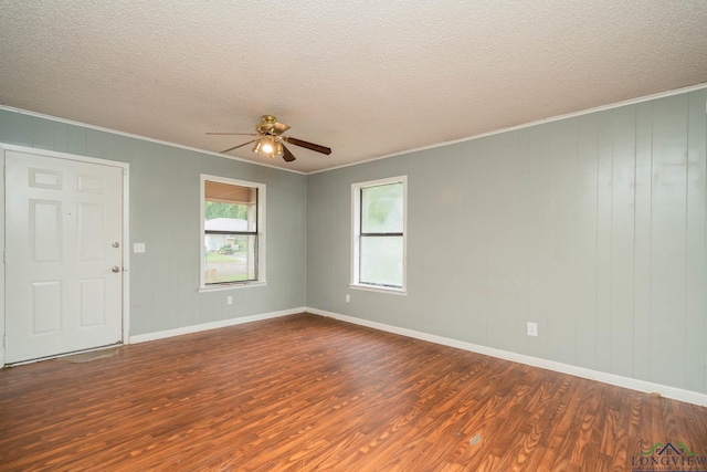 308 N Lee Dr, Gladewater, TX 75647 - spare room featuring dark wood-style floors, ornamental molding, ceiling fan, and a textured ceiling
