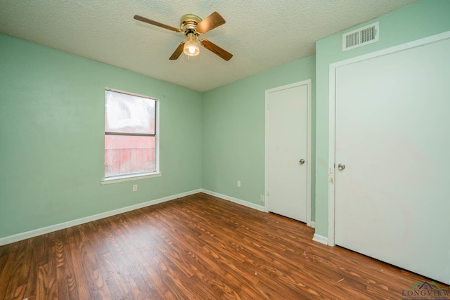 308 N Lee Dr, Gladewater, TX 75647 - unfurnished bedroom featuring wood finished floors, a textured ceiling, and ceiling fan