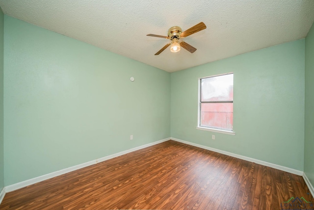 308 N Lee Dr, Gladewater, TX 75647 - spare room with dark wood-type flooring, ceiling fan, and a textured ceiling