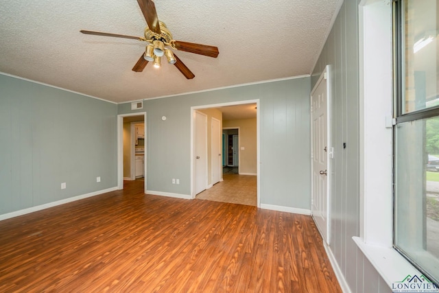 308 N Lee Dr, Gladewater, TX 75647 - unfurnished room featuring wood finished floors, a ceiling fan, a textured ceiling, and crown molding