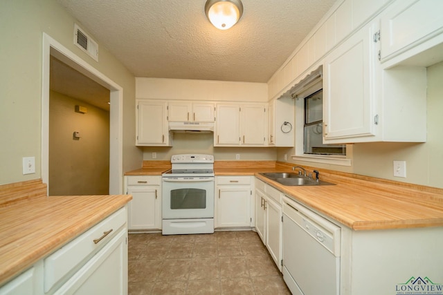 308 N Lee Dr, Gladewater, TX 75647 - kitchen with white appliances, under cabinet range hood, light countertops, white cabinetry, and a textured ceiling
