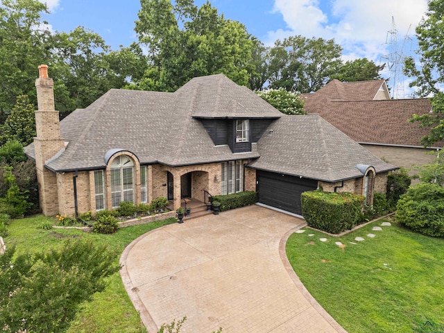 6307 Shady Oaks Dr, Tyler, TX 75703 - french country style house with brick siding, an attached garage, a shingled roof, driveway, and a front yard
