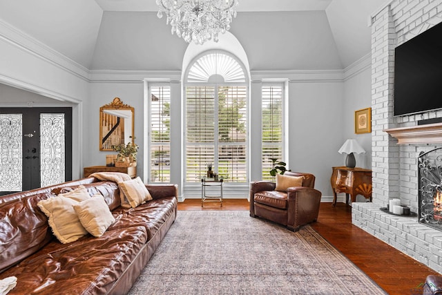 6307 Shady Oaks Dr, Tyler, TX 75703 - living room with a brick fireplace, vaulted ceiling, wood finished floors, a chandelier, and french doors