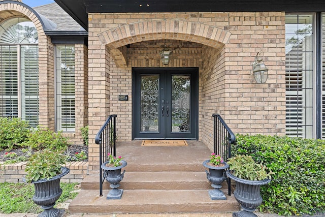 6307 Shady Oaks Dr, Tyler, TX 75703 - view of exterior entry with french doors, brick siding, and roof with shingles