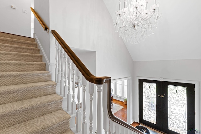 6307 Shady Oaks Dr, Tyler, TX 75703 - staircase featuring high vaulted ceiling, a chandelier, french doors, and wood finished floors