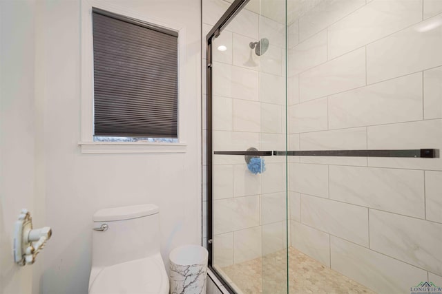 bathroom with toilet and a stall shower