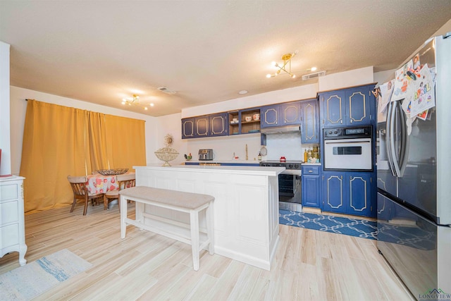 kitchen with visible vents, light wood-style floors, open shelves, light countertops, and appliances with stainless steel finishes