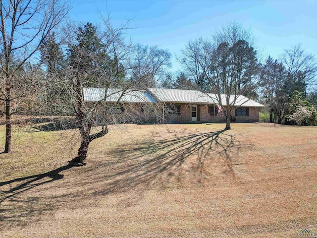 view of front facade with brick siding and a front yard