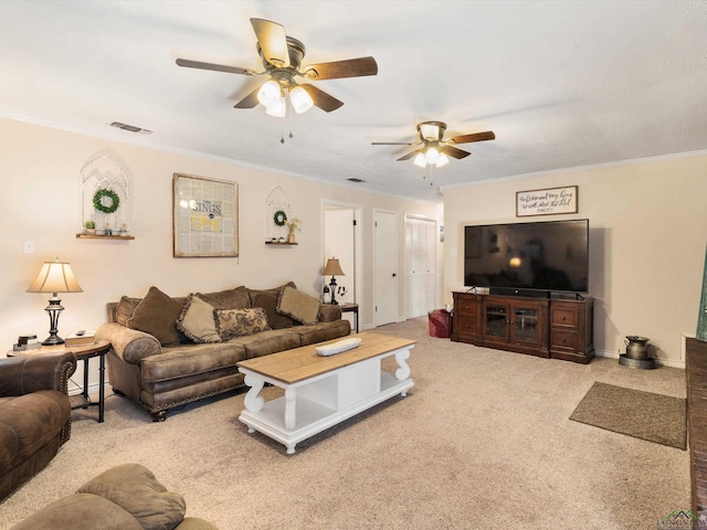 carpeted living room featuring visible vents, baseboards, crown molding, and ceiling fan