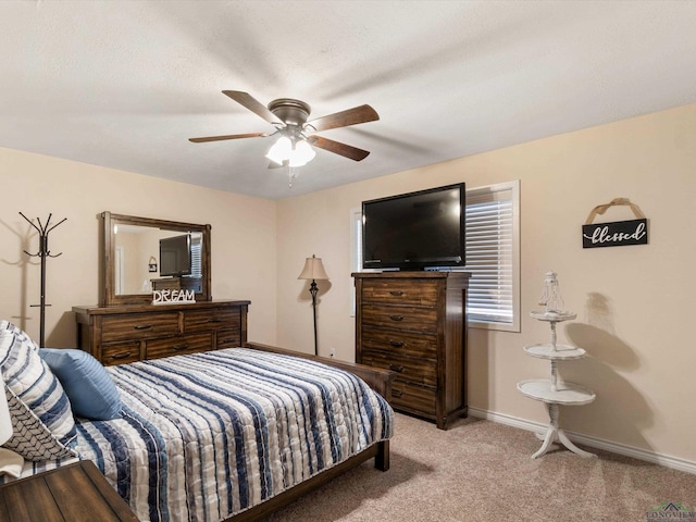 bedroom featuring a textured ceiling, a ceiling fan, baseboards, and light carpet