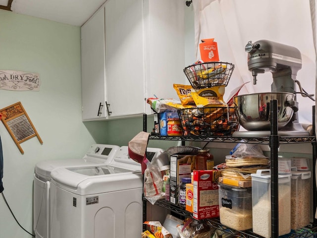 clothes washing area featuring cabinet space and separate washer and dryer