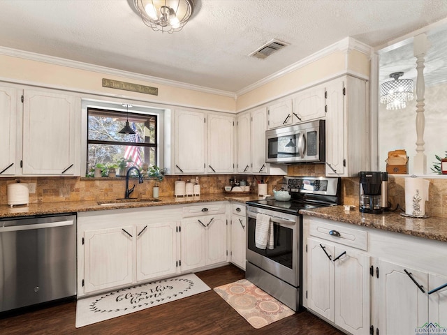 kitchen featuring visible vents, a sink, dark wood-style floors, appliances with stainless steel finishes, and crown molding