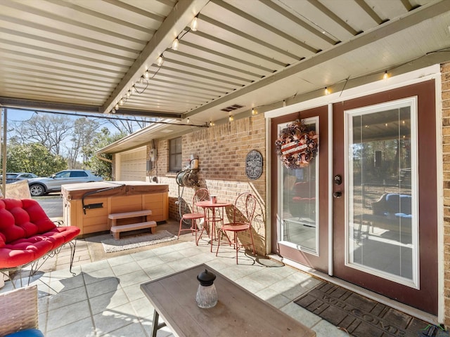 view of patio with visible vents and a hot tub