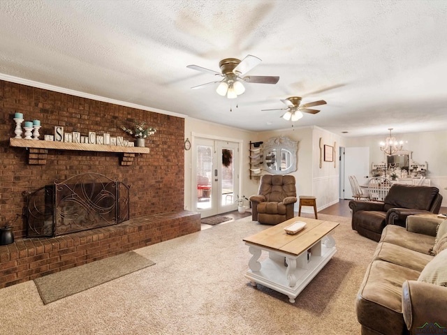 living area featuring carpet, a fireplace, french doors, a textured ceiling, and ceiling fan with notable chandelier