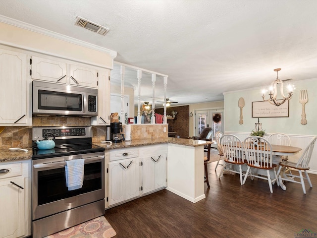 kitchen with visible vents, appliances with stainless steel finishes, dark wood-type flooring, and a peninsula