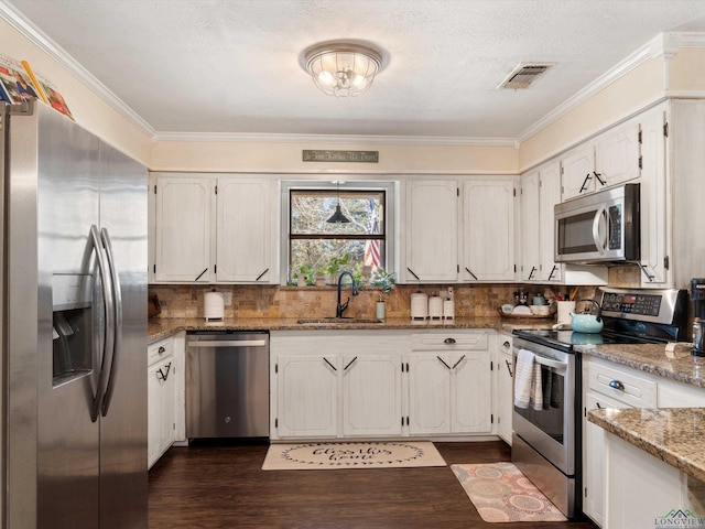 kitchen featuring visible vents, ornamental molding, appliances with stainless steel finishes, and a sink